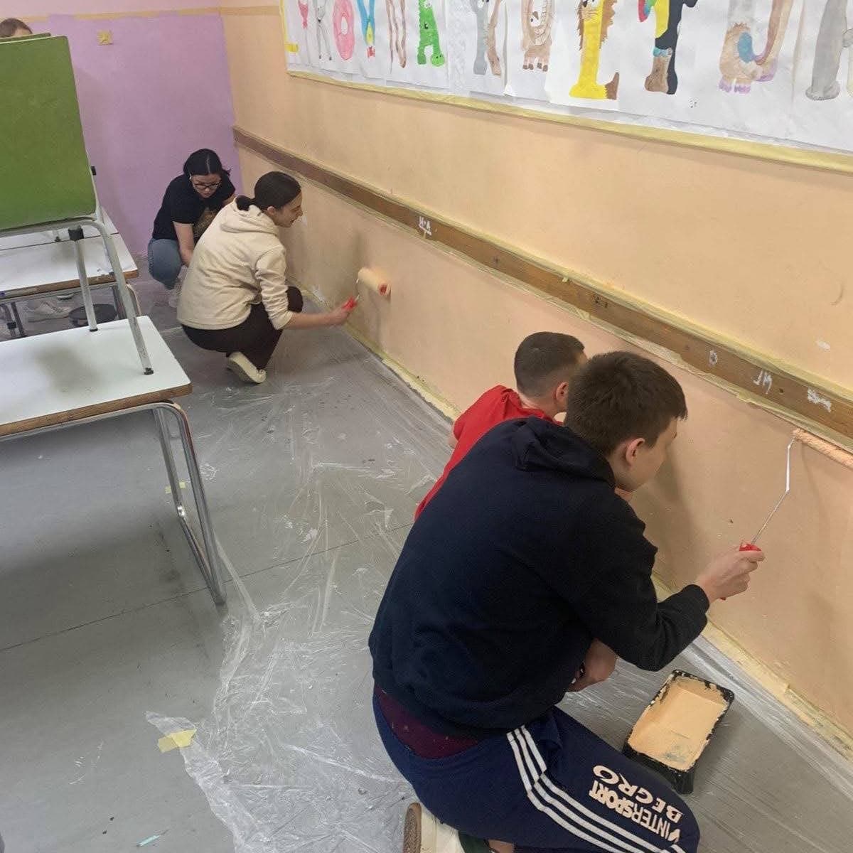 Kinderen en studenten aan het werk bij school in Bosnië